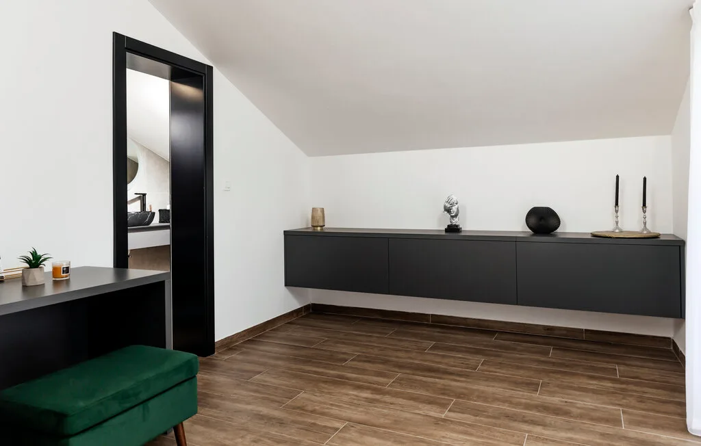 Una estancia moderna con un largo mueble de pared y suelo de aspecto madera.