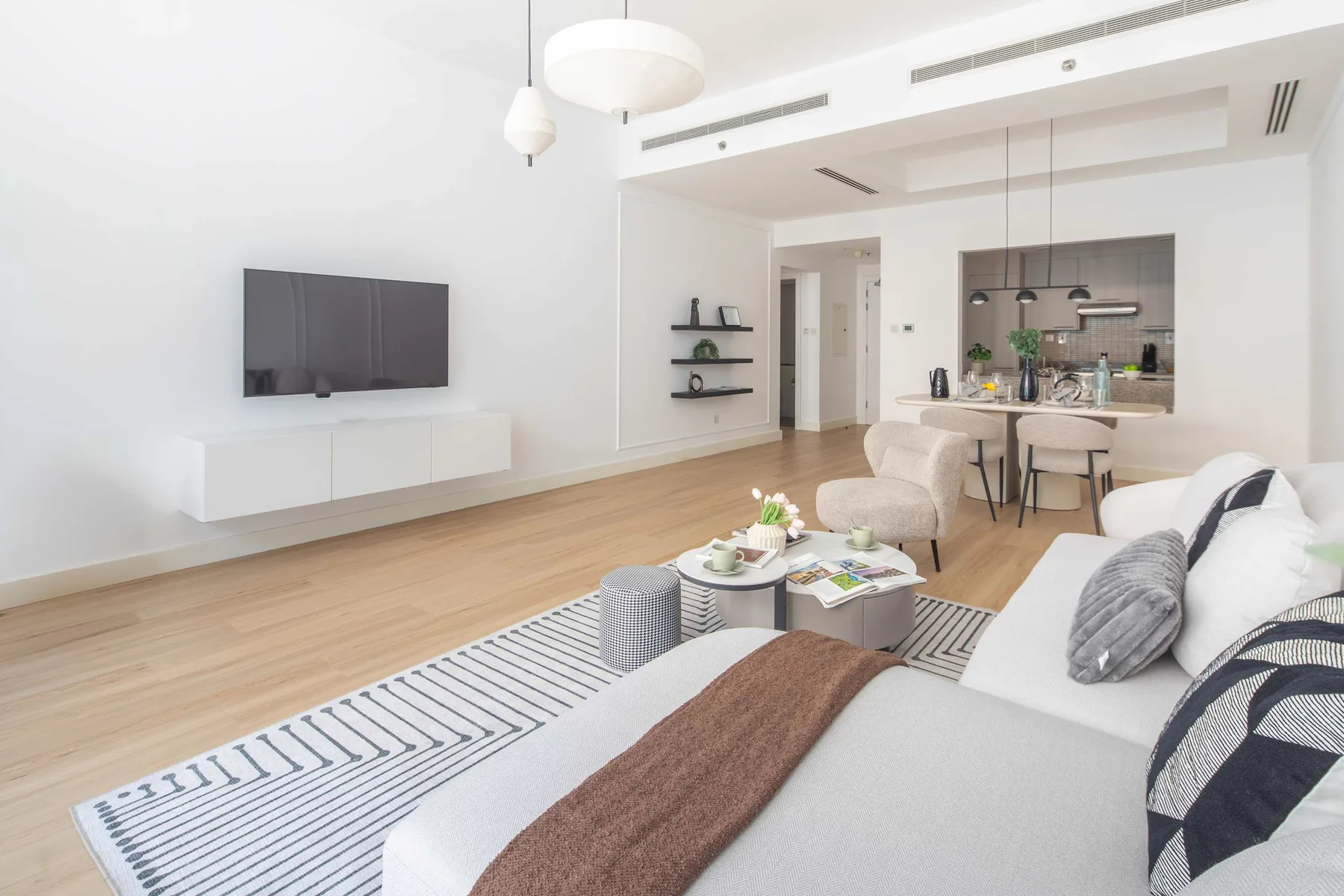 Una luminosa sala de estar y cocina de concepto abierto con mesa de comedor y asientos.