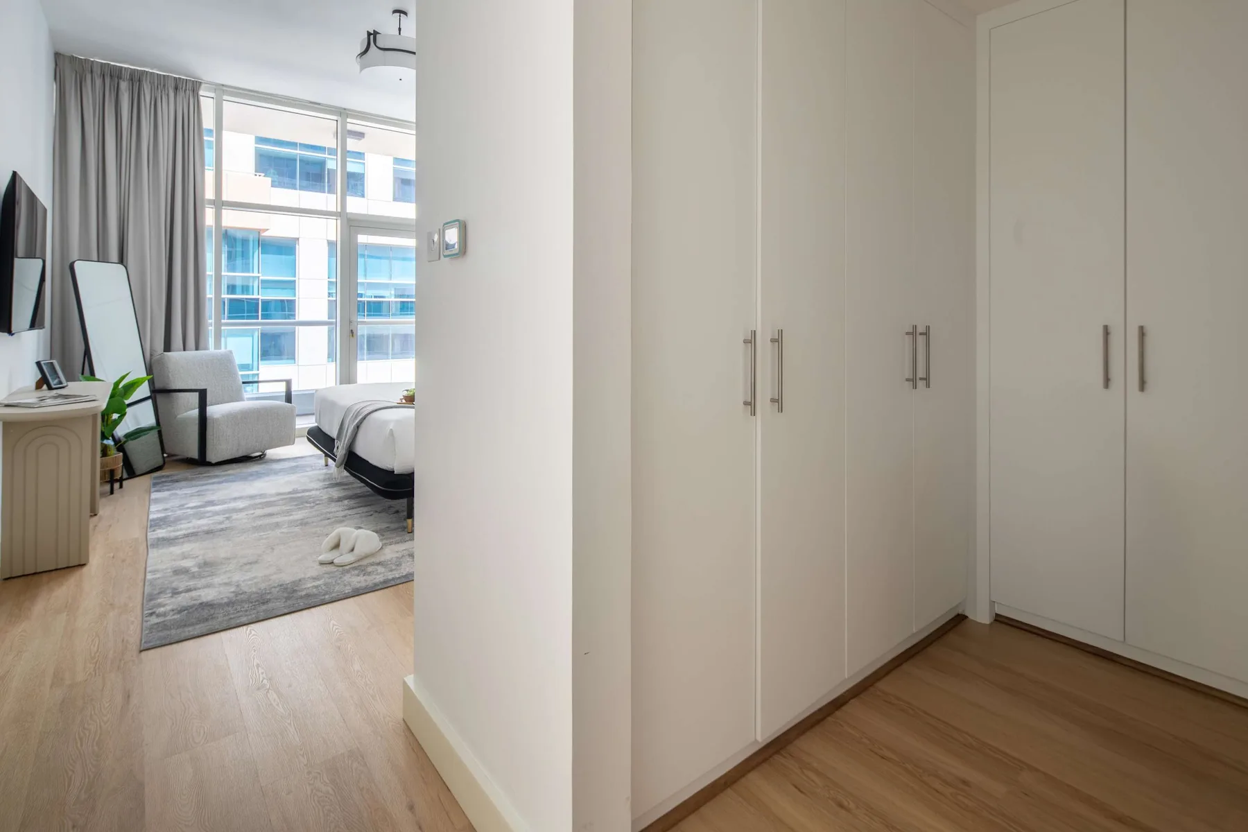 Un dormitorio con una cama, una zona de estar y armarios empotrados.