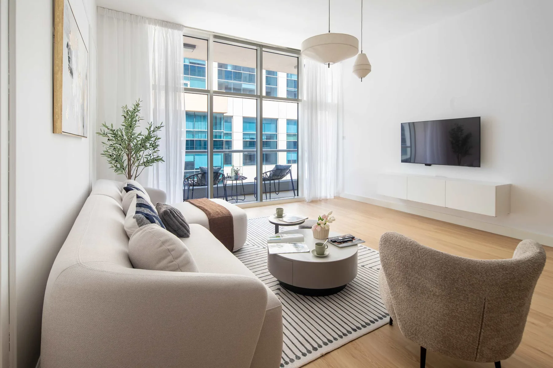Sala de estar luminosa con sofá, mesa de centro y televisor.