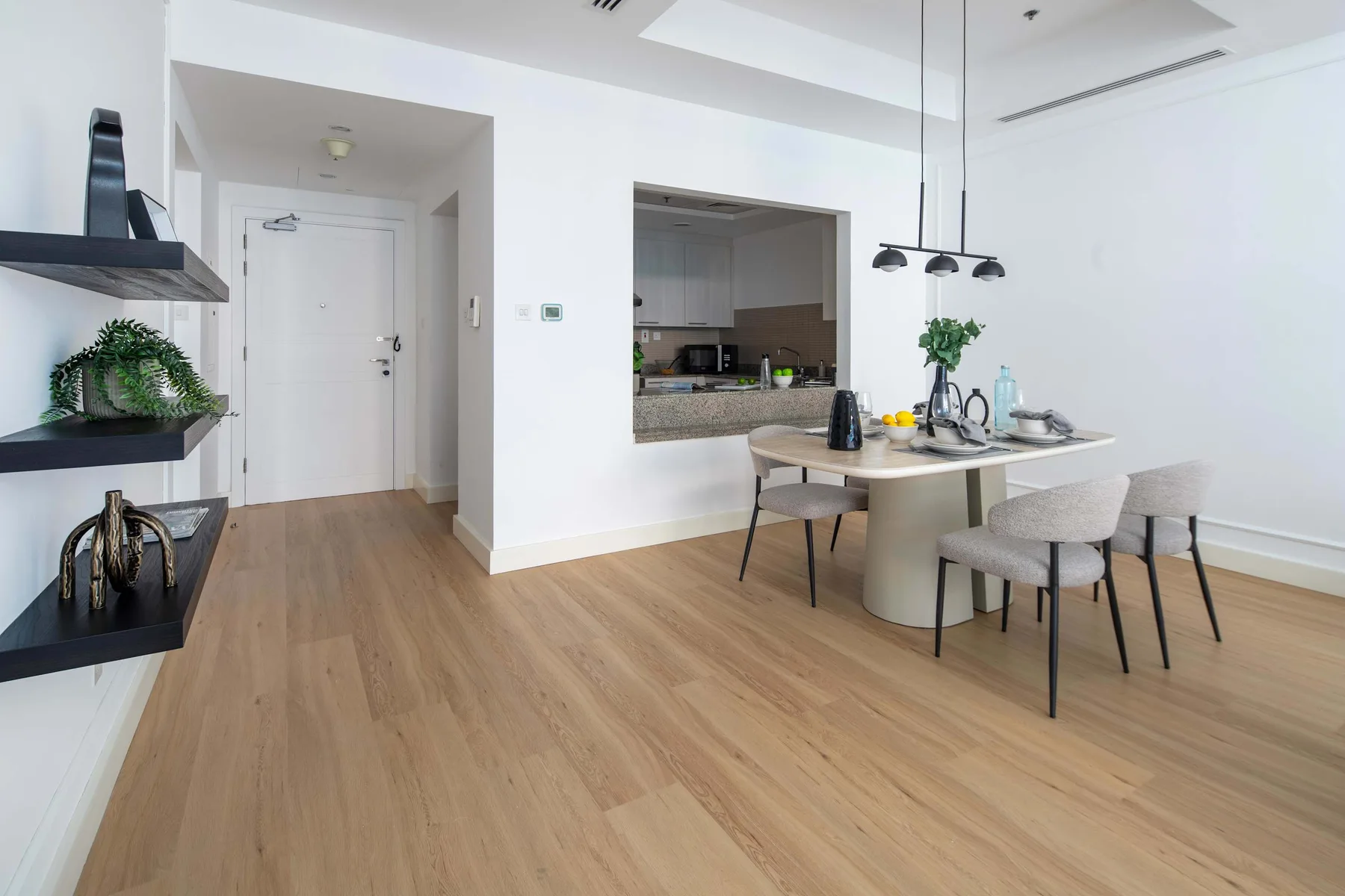 Un comedor luminoso con una mesa y una abertura hacia la cocina.