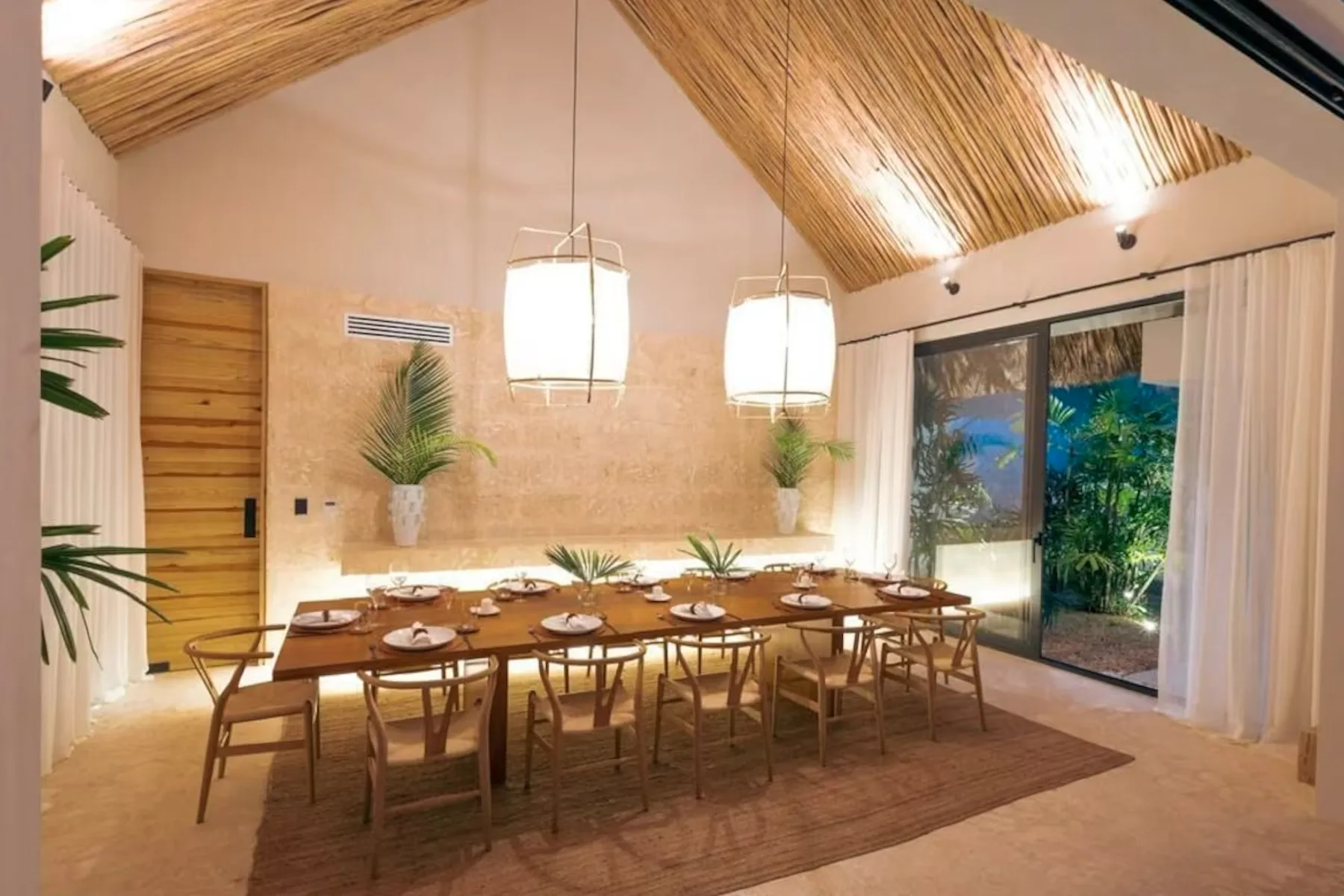 A dining area with a long wooden table set beneath a sloped ceiling.