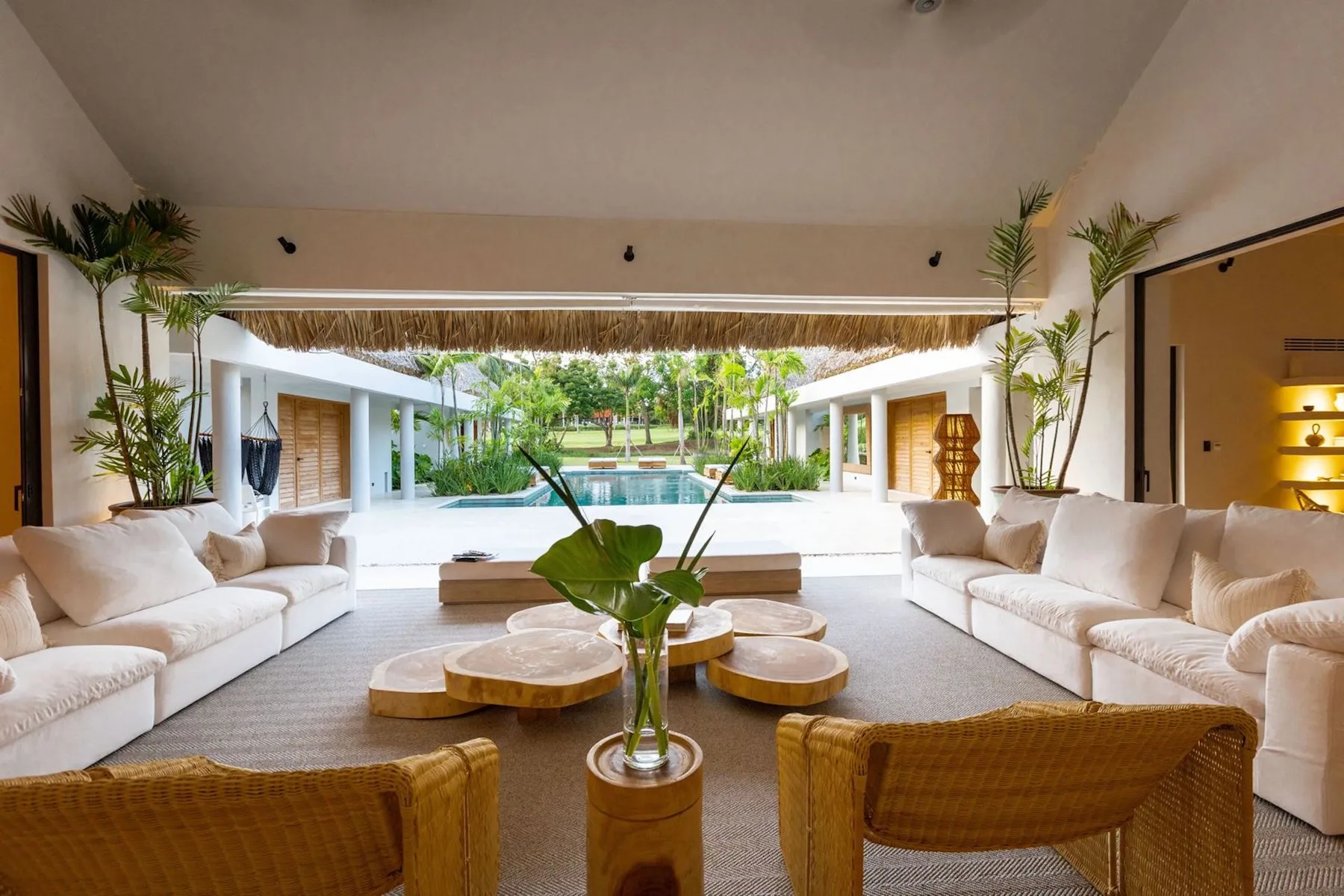 An open lounge with seating and a view of a courtyard pool.