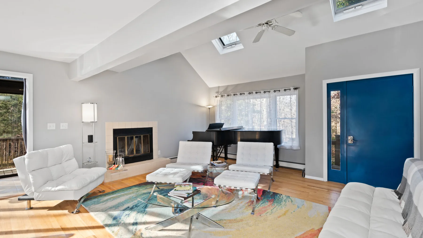 A bright living room with seating around a glass coffee table.