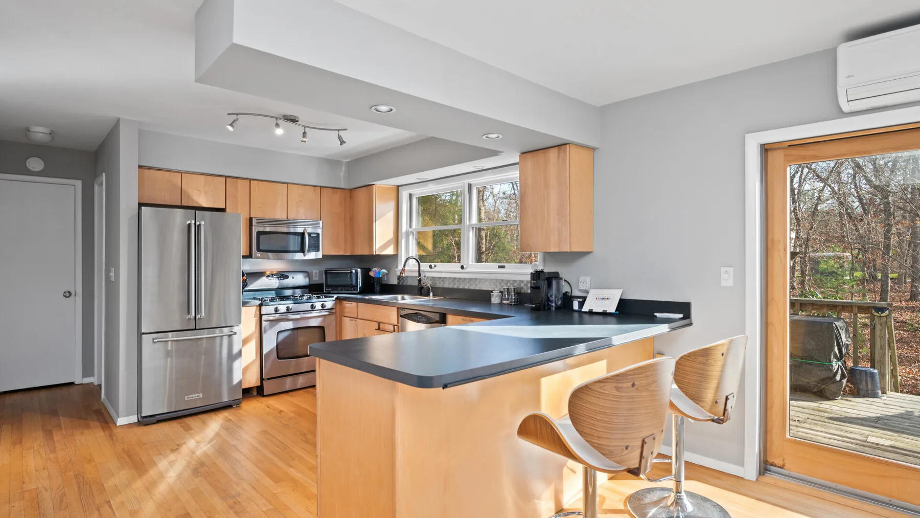 An open-plan kitchen with a central island and large windows.