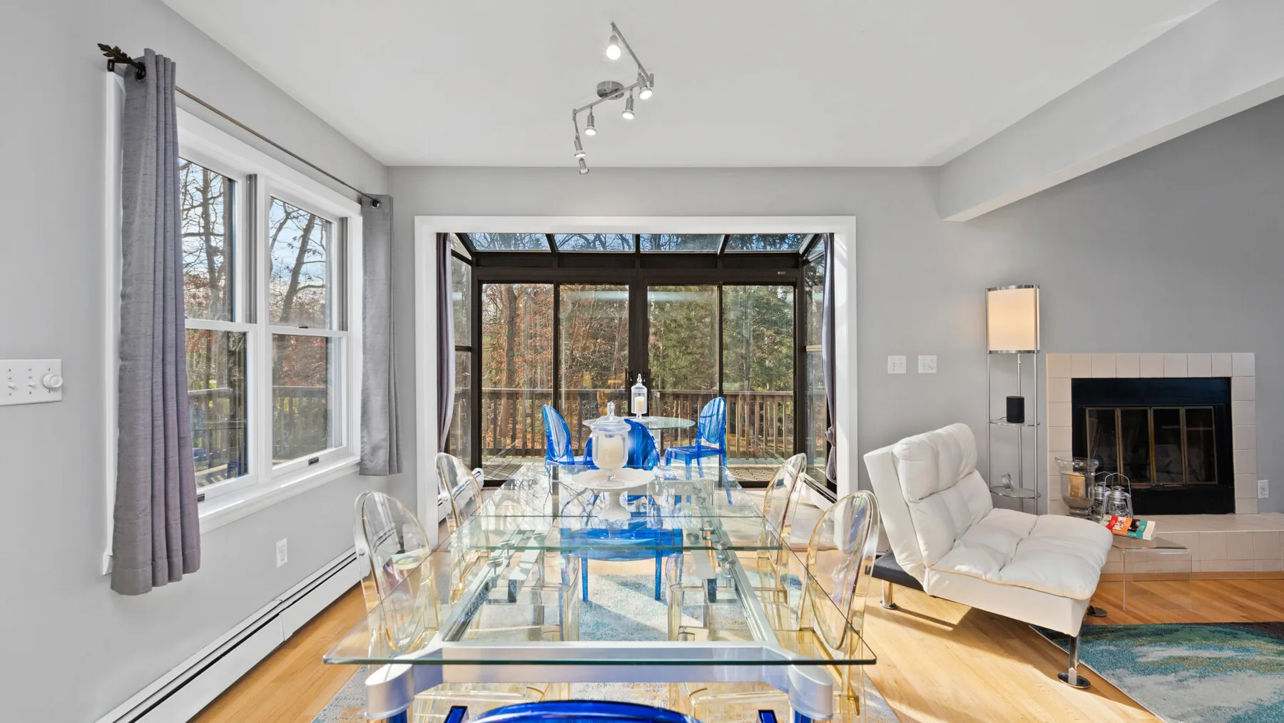 A bright dining and living area opens onto a glass-enclosed patio.