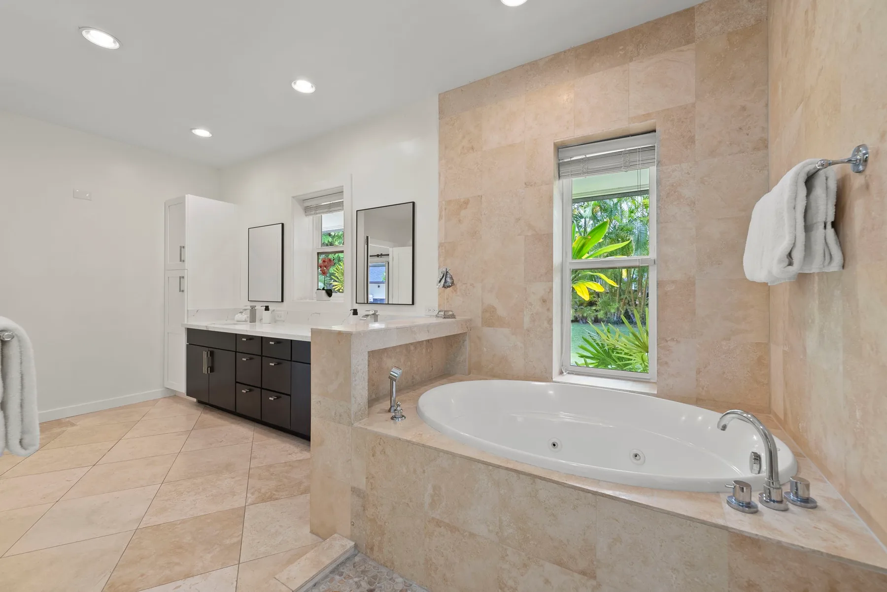 Un baño amplio con bañera y tocador junto a una ventana.