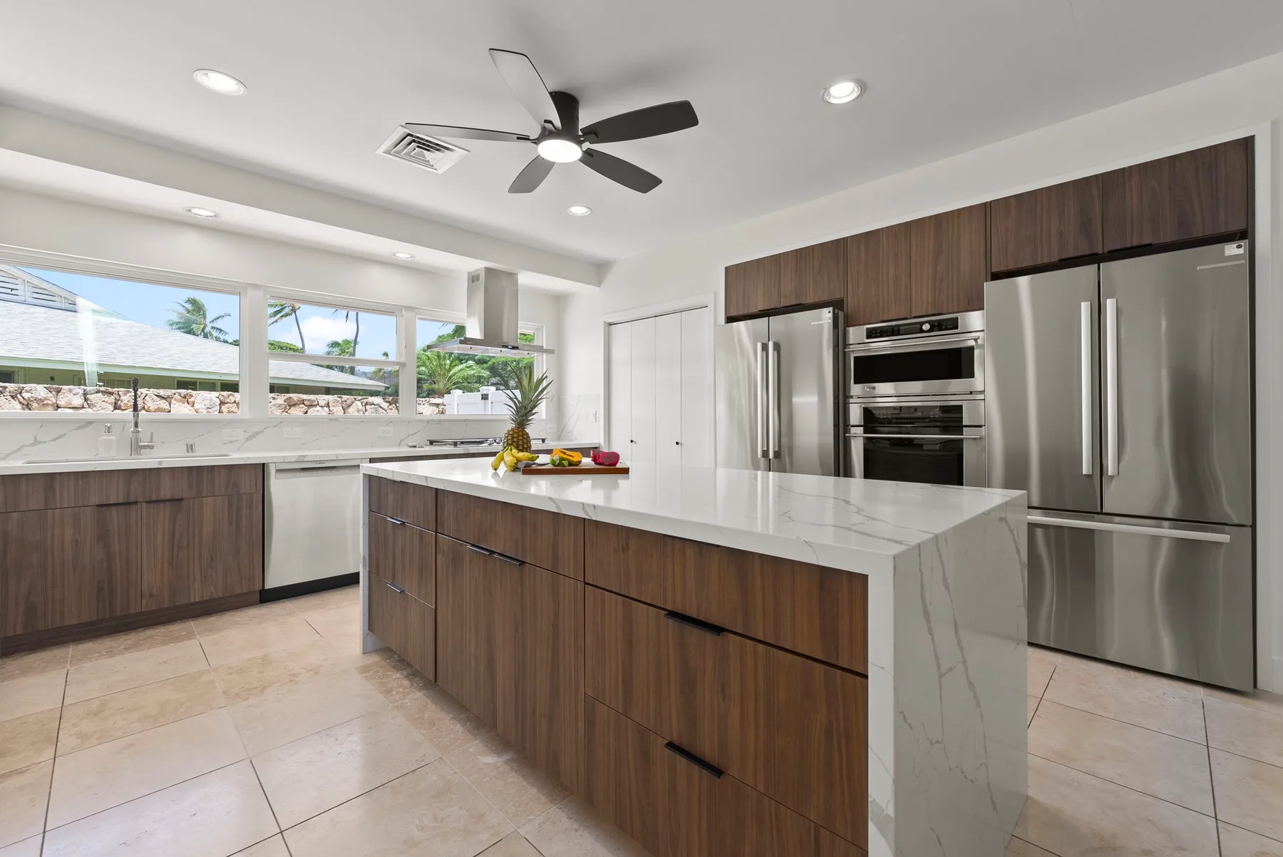 Una cocina luminosa con gabinetes de madera, electrodomésticos de acero inoxidable y una isla central.