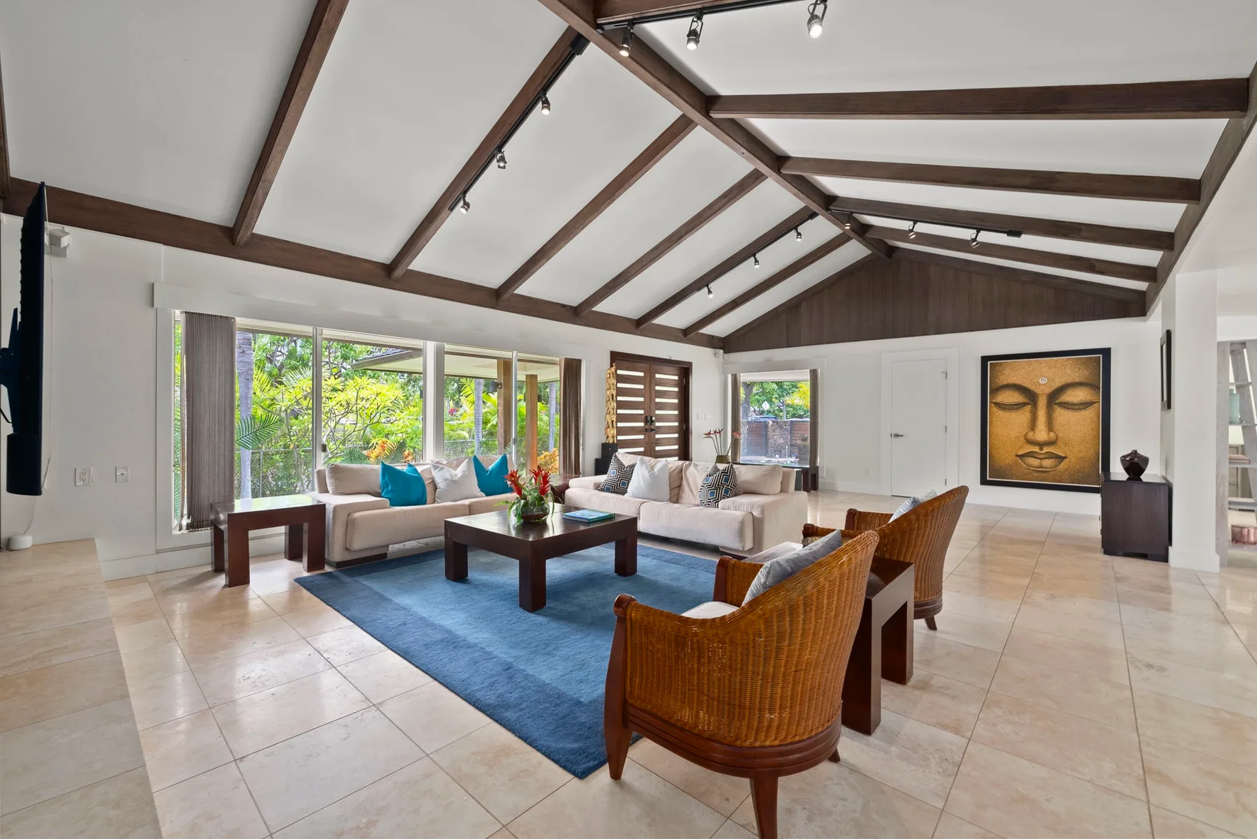 Una sala luminosa con techo alto, asientos y grandes ventanas.