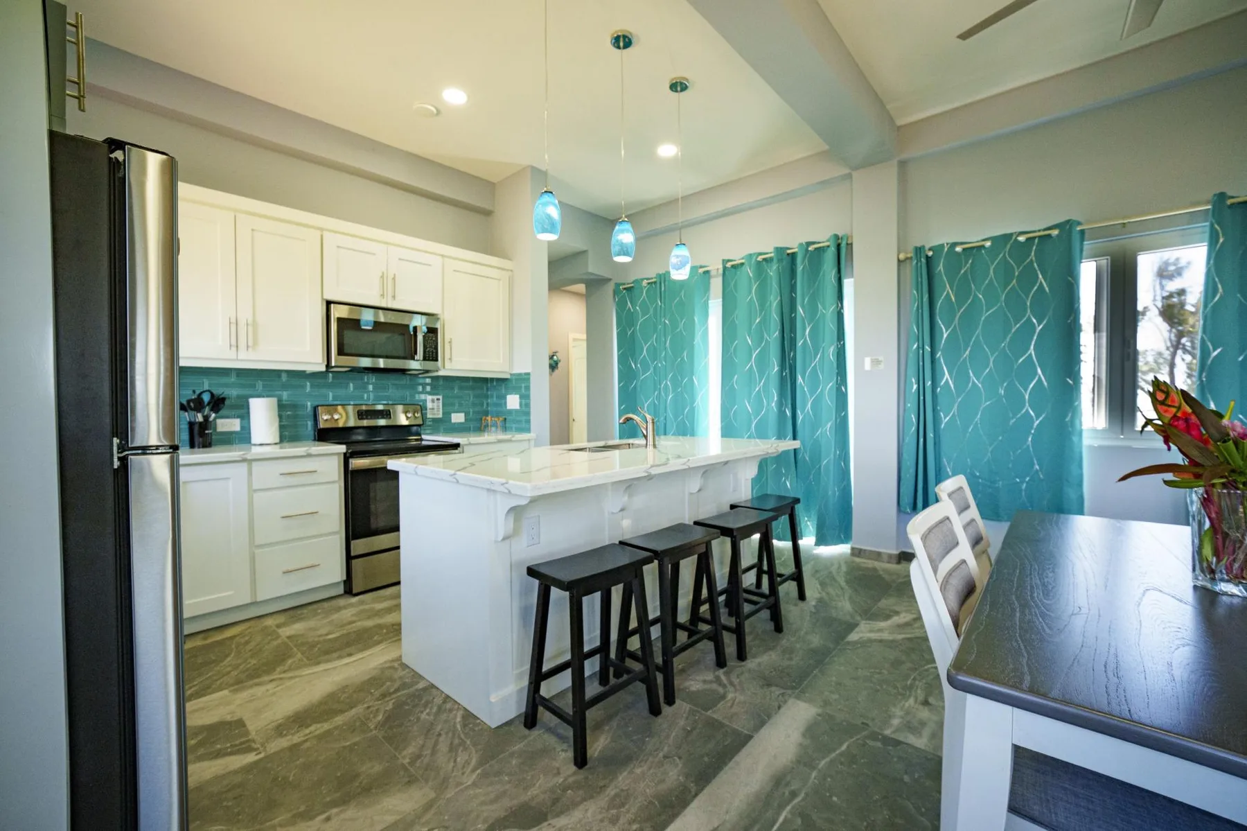 An open kitchen and dining area features a central island with bar seating.