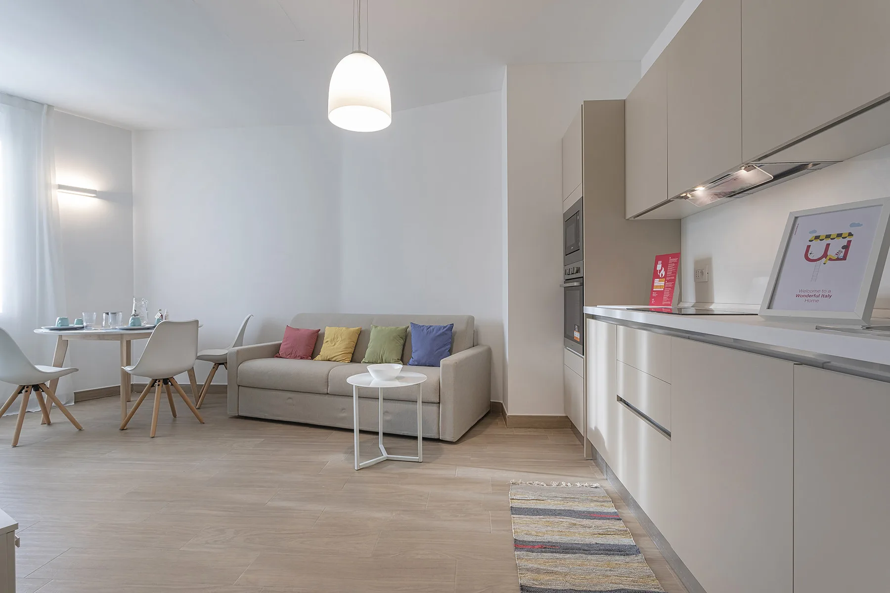 Una luminosa sala de estar diáfana con mesa de comedor, asientos y cocina.