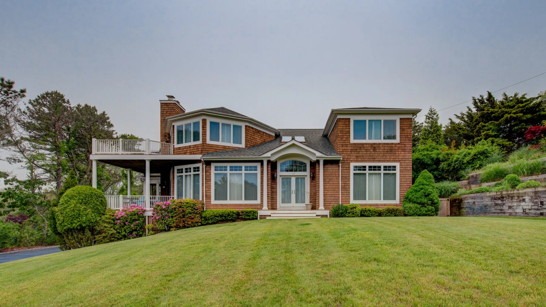 A two-story brick house stands beyond a broad green lawn.
