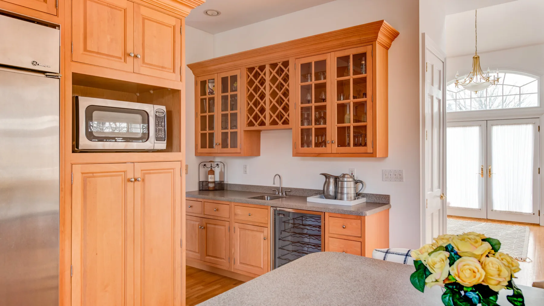 Una cocina de tonos cálidos con gabinetes de madera y una encimera.