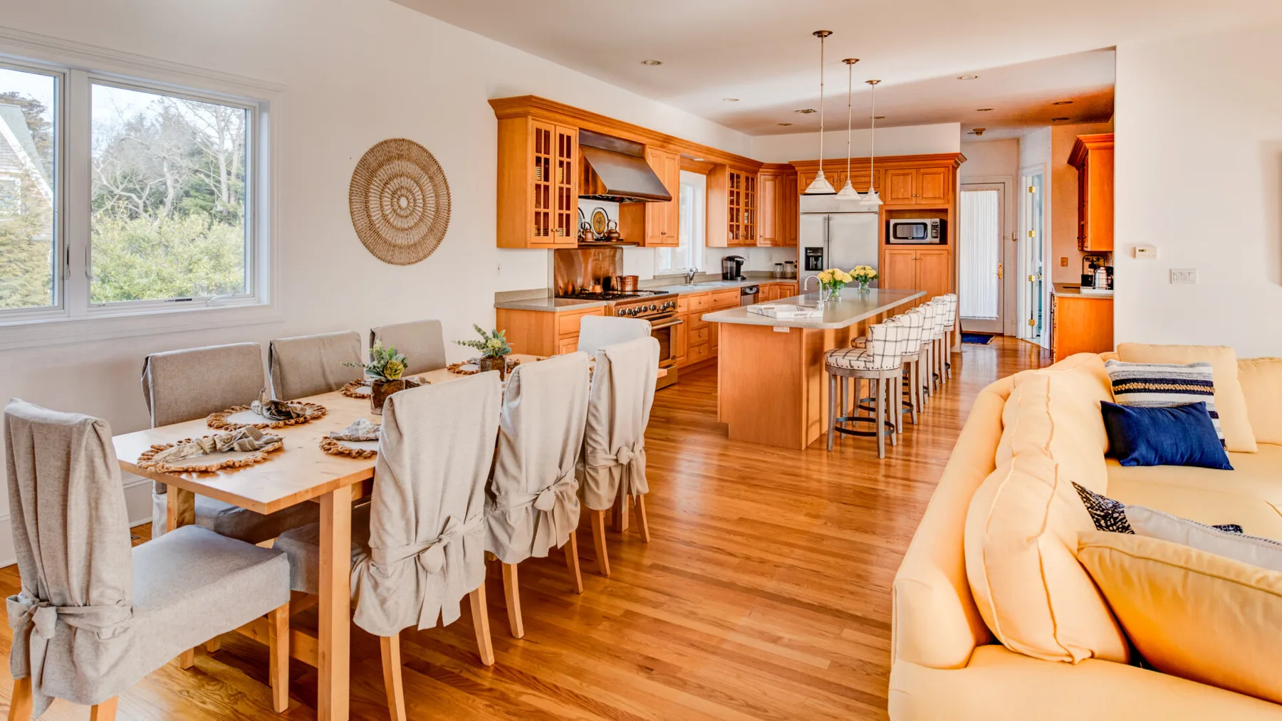 A bright open-plan kitchen and dining area with a counter and seating.