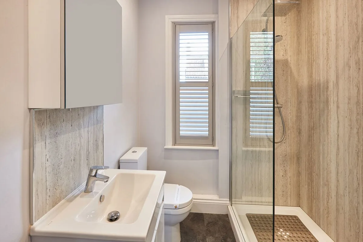 Un baño con lavabo, inodoro y ducha de cristal.