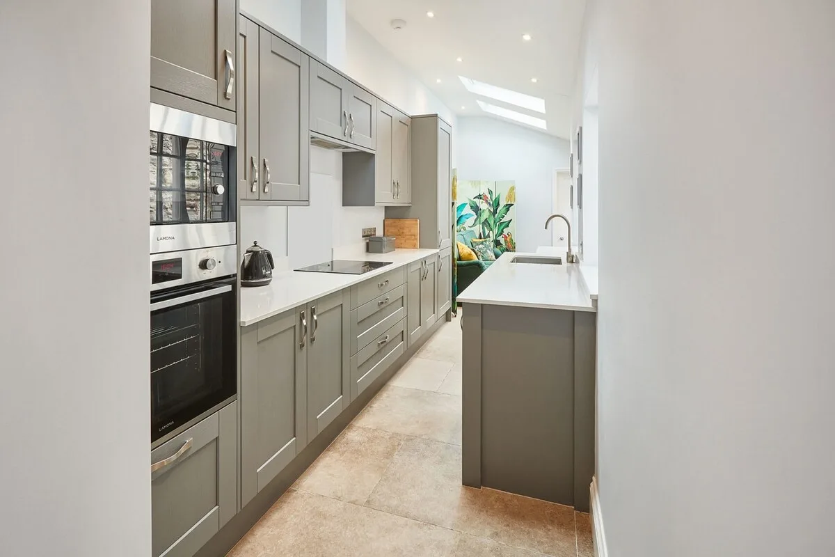 Una cocina moderna y luminosa con gabinetes grises y una isla central.