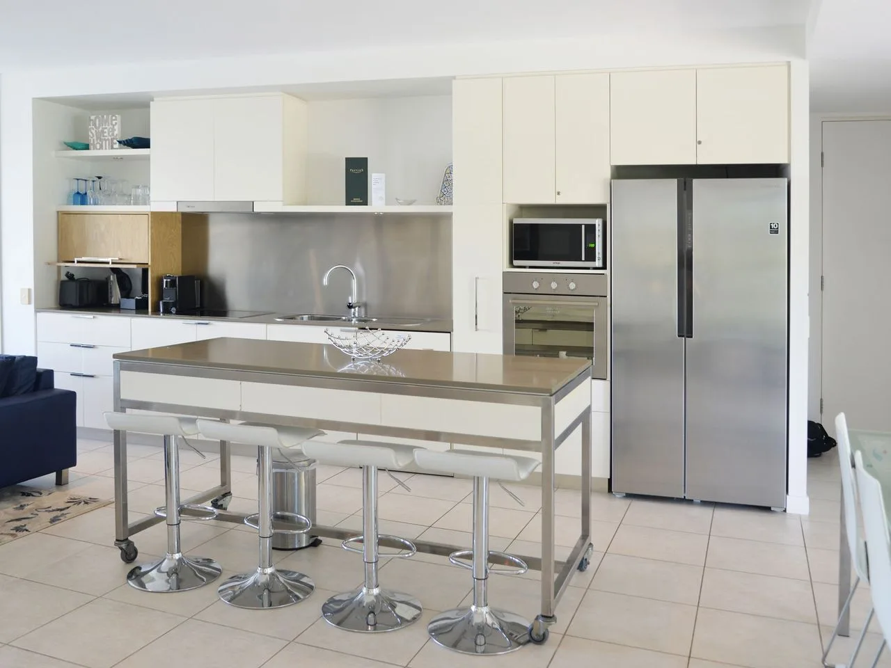 A bright modern kitchen with a central island and stainless steel appliances.