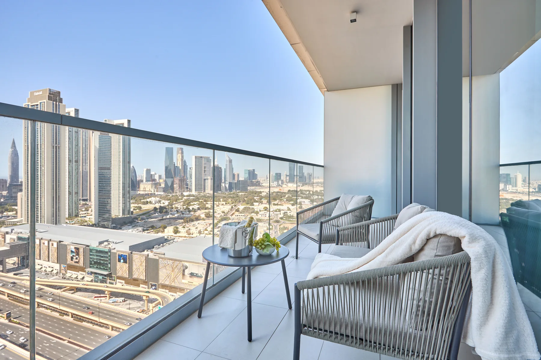 A balcony seating area overlooks a city skyline.