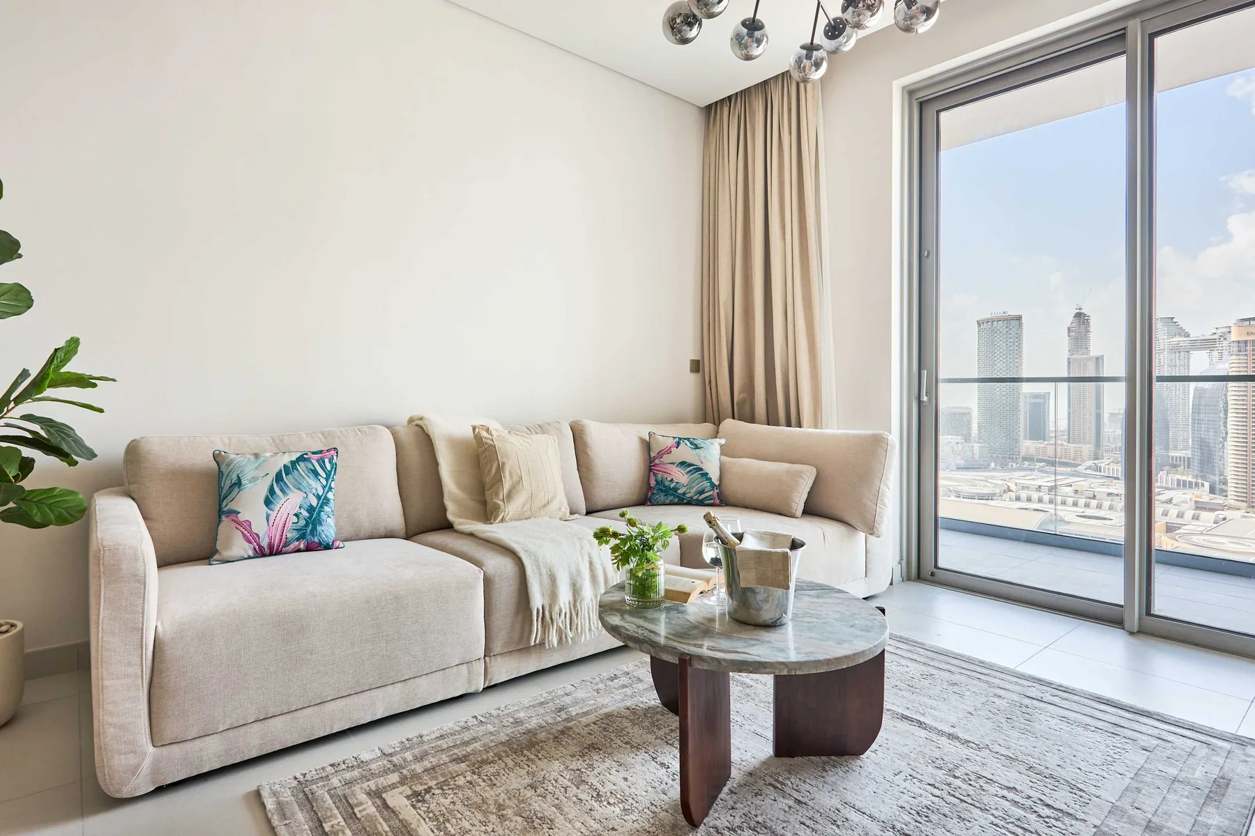 A bright living room with a sectional sofa beside large glass doors.