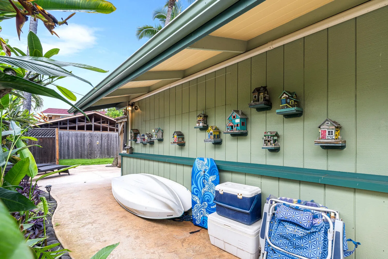 Un patio cubierto con pequeñas casitas decorativas para pájaros en una pared verde.