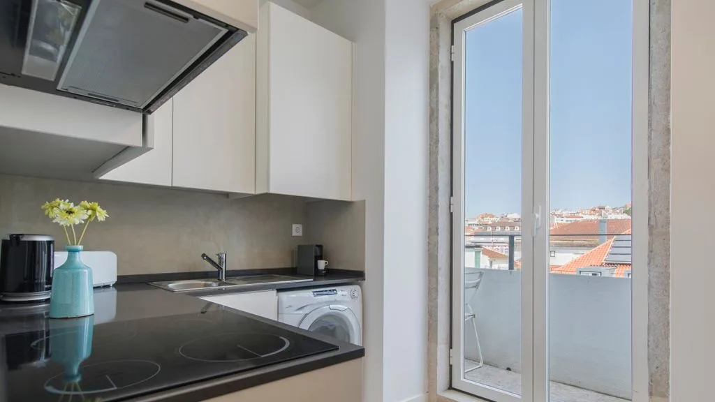 Una cocina moderna con placa de cocción y puertas de vidrio que dan a un balcón.