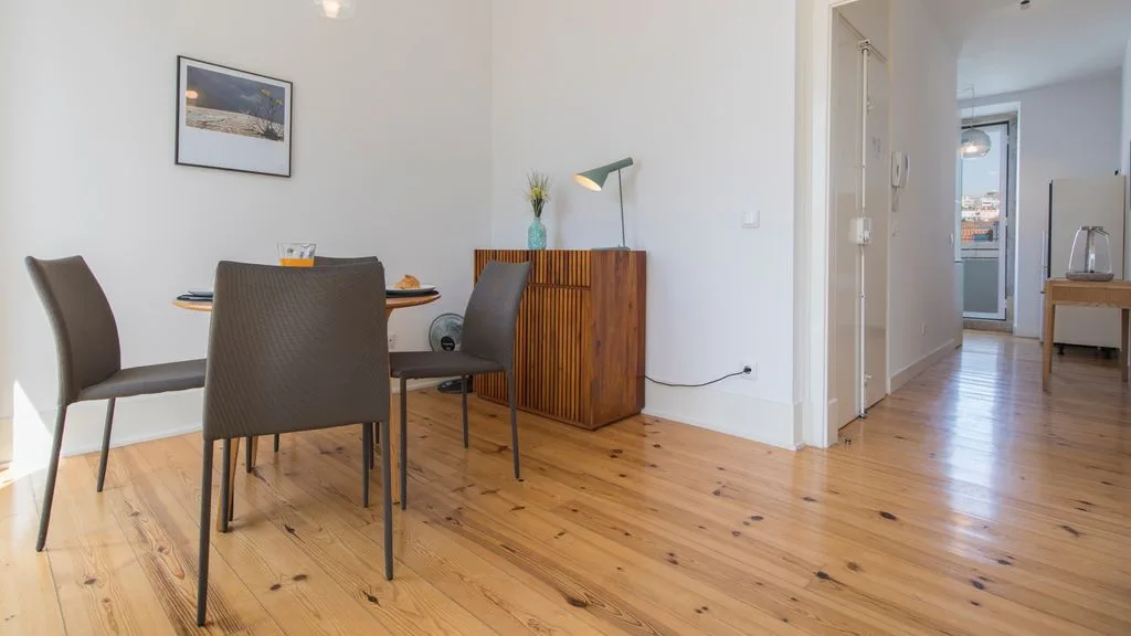 Un comedor con una mesa y sillas junto a un mueble de madera.