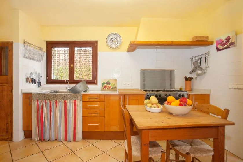 A warm-toned kitchen with wooden cabinets and a dining table.