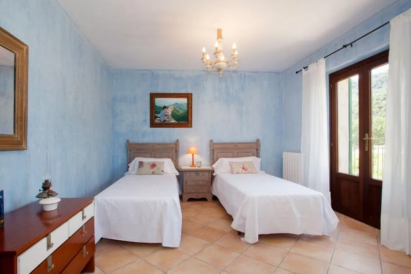 A bedroom with two single beds and a small bedside table.