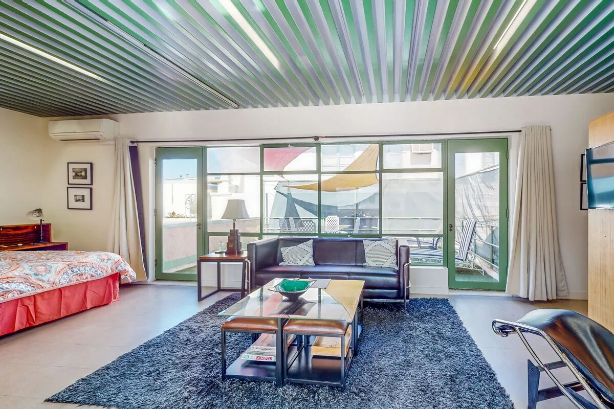 A bright living room with seating facing large windows and a glass coffee table.