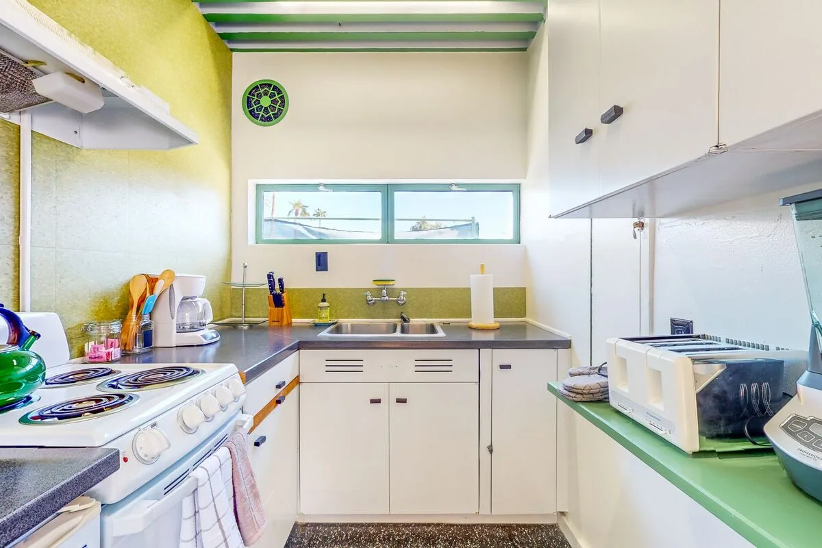 A compact kitchen with a sink, counter, and cooking appliances.