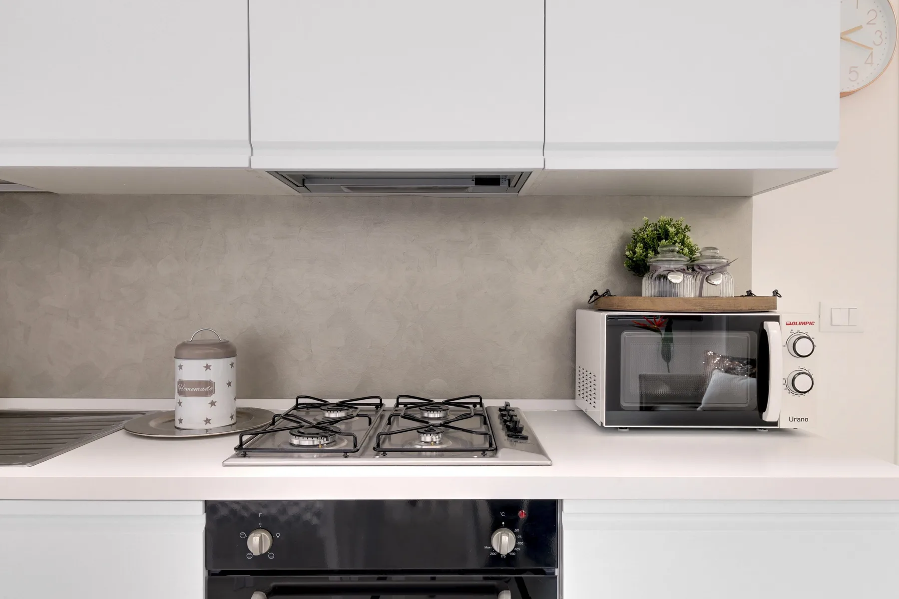 Una cocina luminosa con una placa de gas y un microondas sobre la encimera.