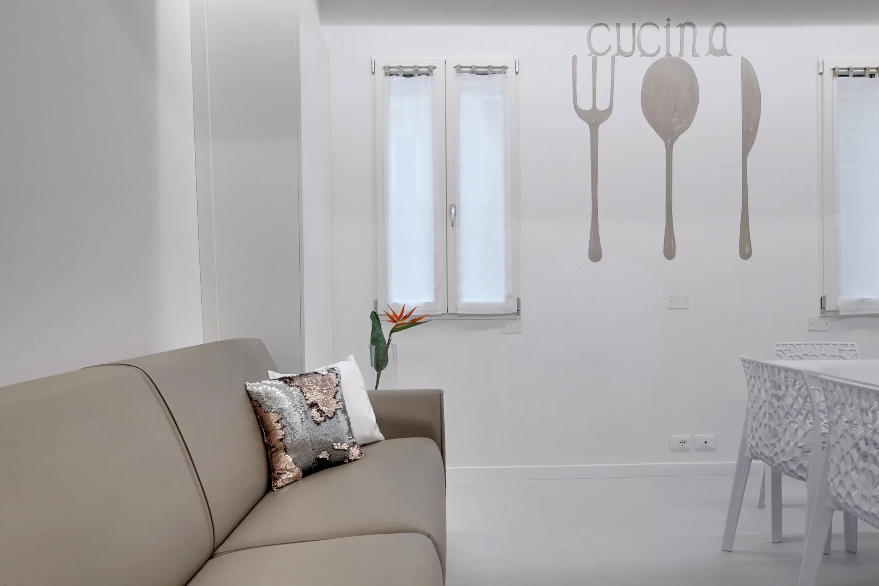 Una luminosa sala de estar y comedor con asientos, una mesa y adornos en la pared.