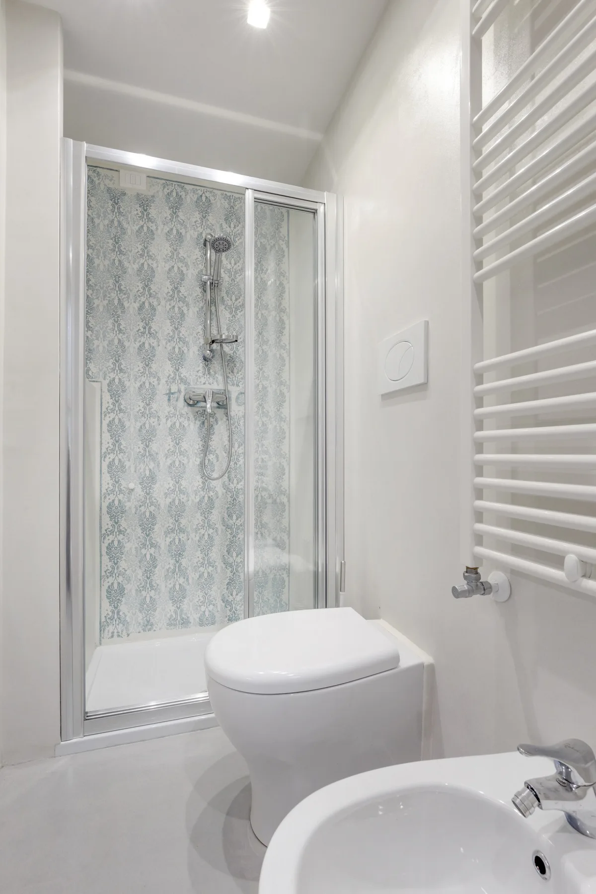Un baño con una ducha acristalada y un inodoro.