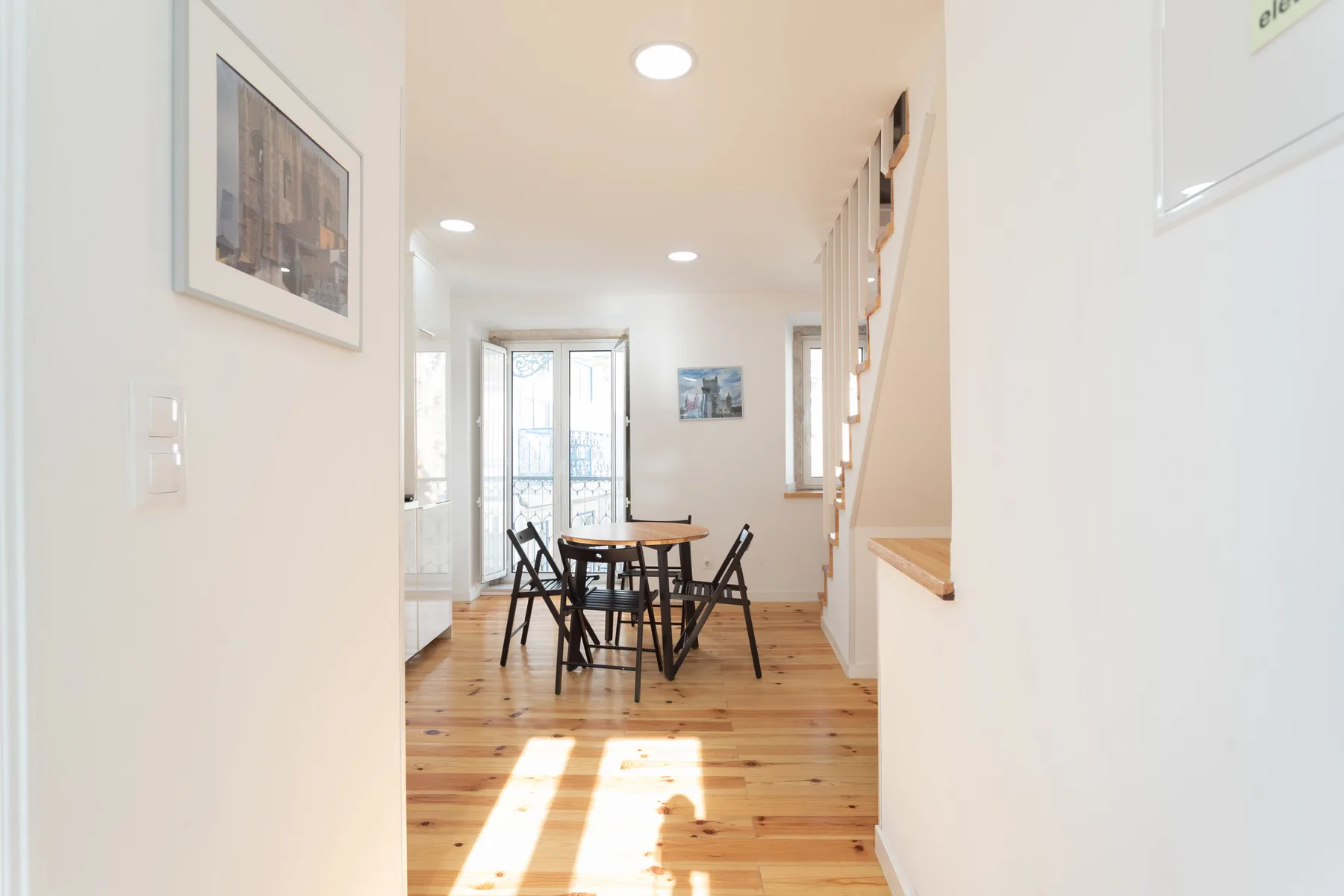 Un comedor luminoso con una mesa y sillas junto a las ventanas.