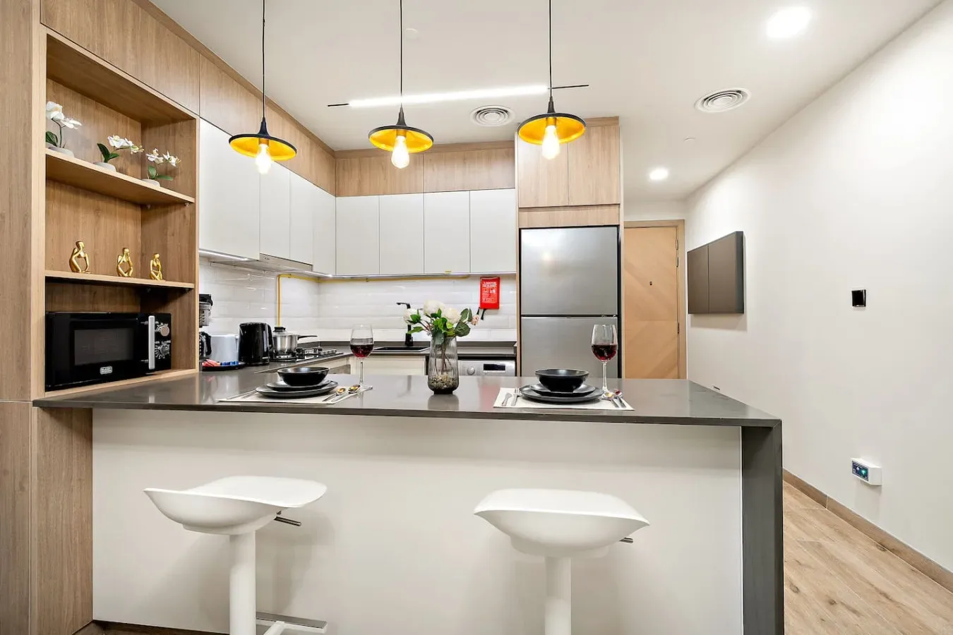 A modern kitchen with a wide island and two stools.