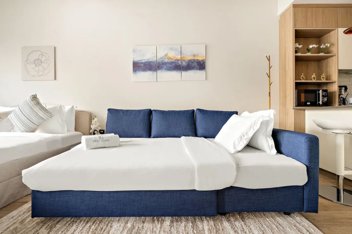 A living room with blue-and-white seating and artwork on the wall.