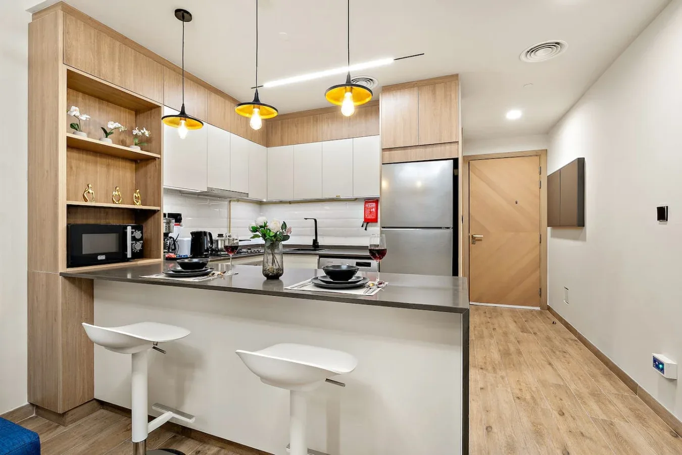 A modern kitchen with a peninsula counter, cabinets, and pendant lights.