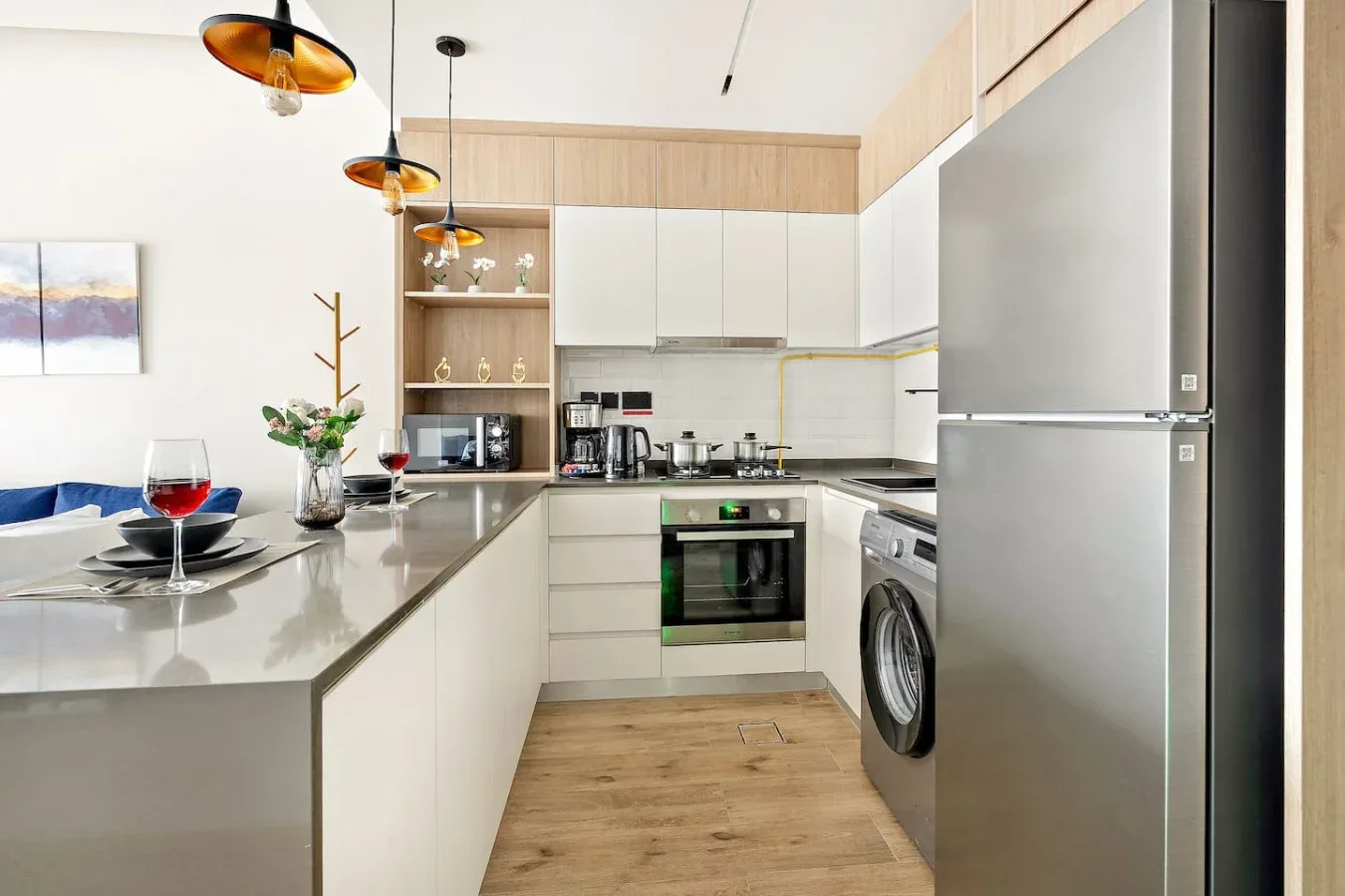 A modern kitchen with light cabinetry, a countertop, and stainless steel appliances.
