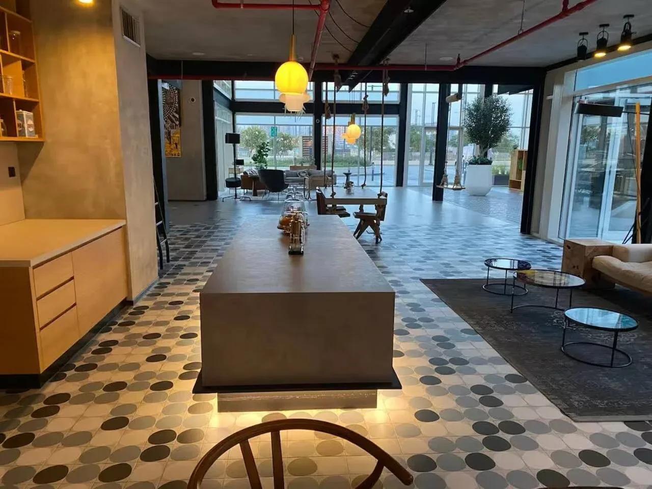 A spacious lobby with a long counter, patterned floor, and large windows.