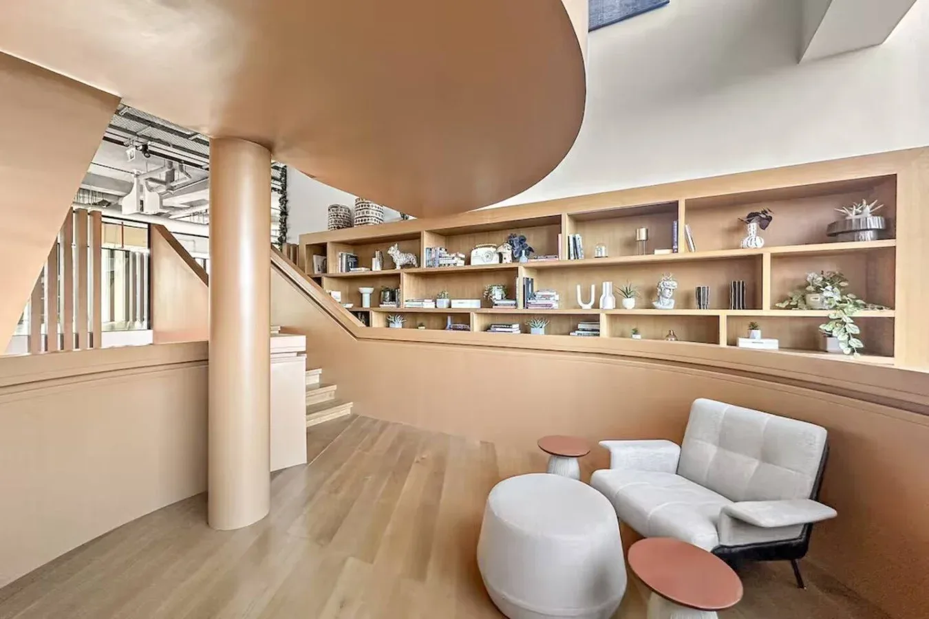 A modern lounge with tiered wooden shelving and comfortable seating.