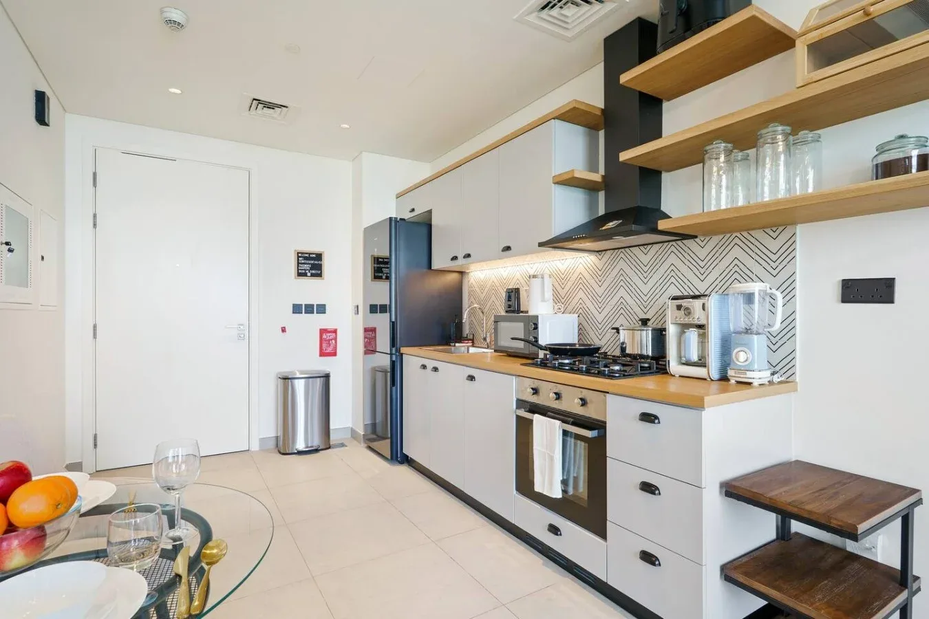 A modern kitchen with a tiled backsplash and countertop appliances.