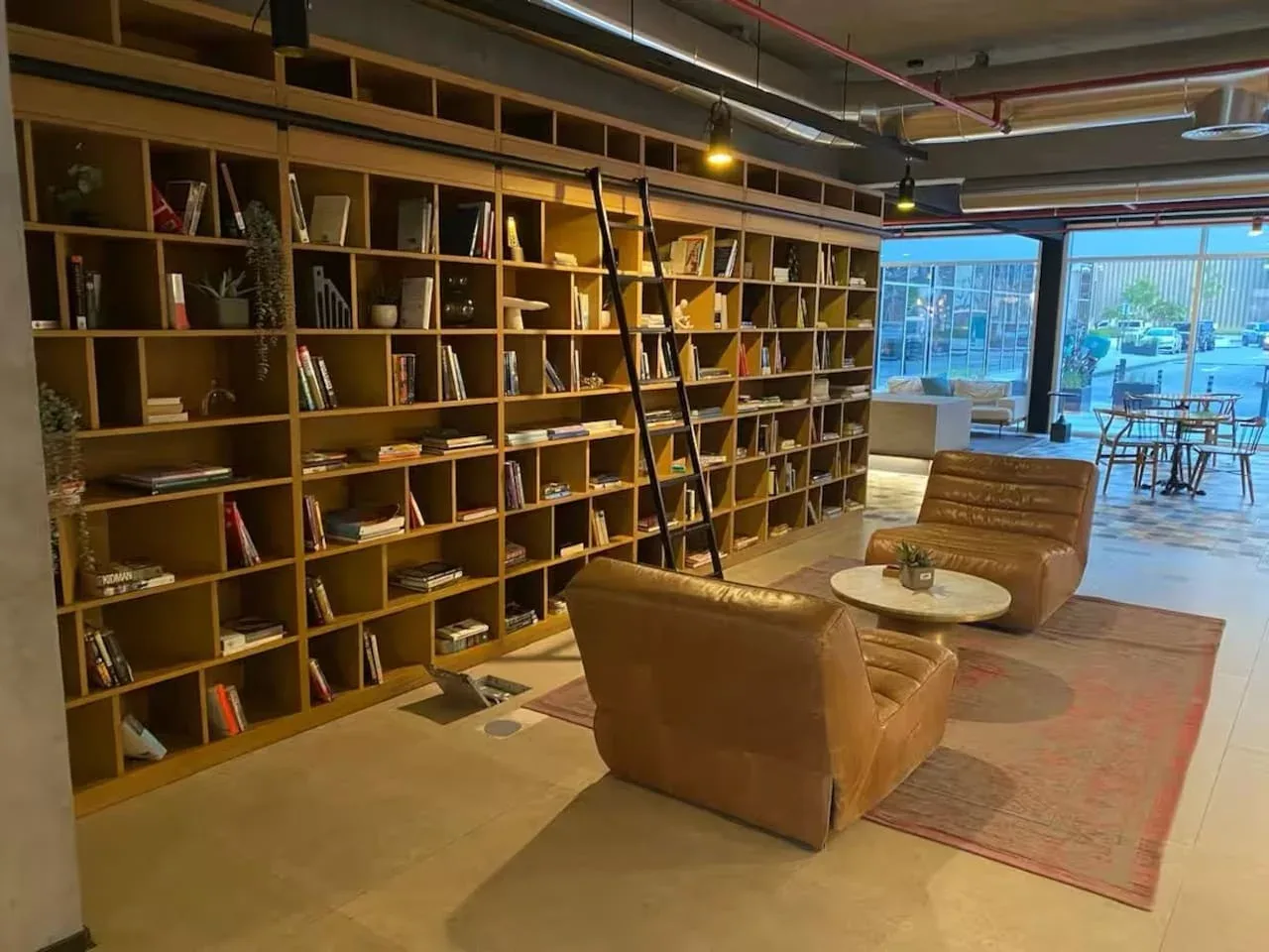 A lounge with leather seating and a long wall of bookshelves.