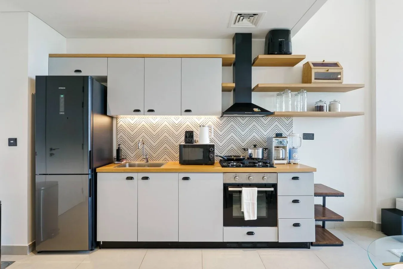 A modern kitchen with white cabinets, a refrigerator, and a stove.
