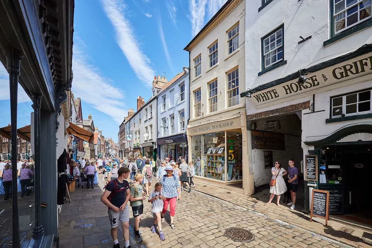 A busy pedestrian street lined with shops and historic-looking buildings.