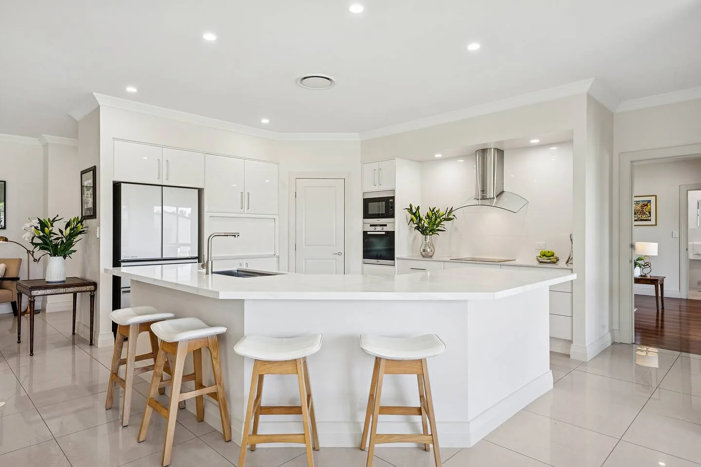 A bright kitchen with a central island and stools.