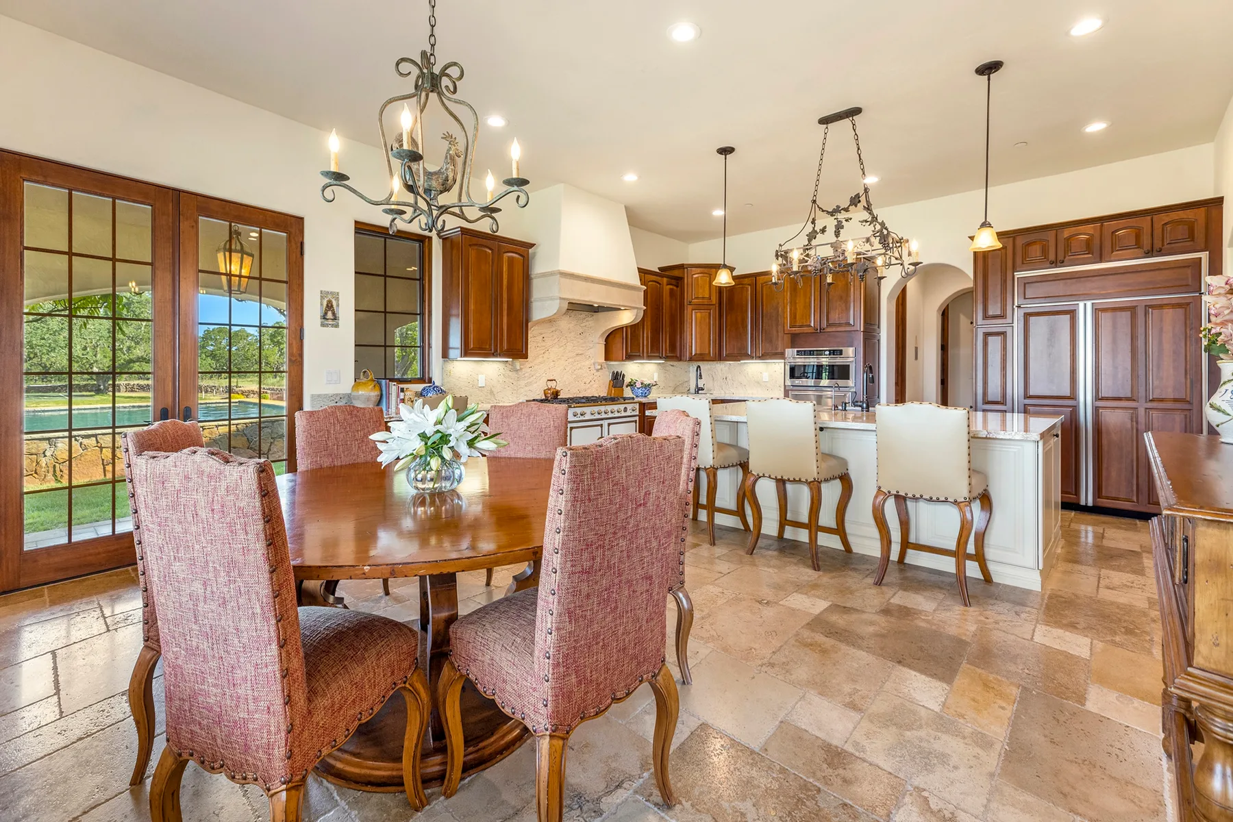 A dining area opens onto a kitchen, with a table and chairs in the foreground.