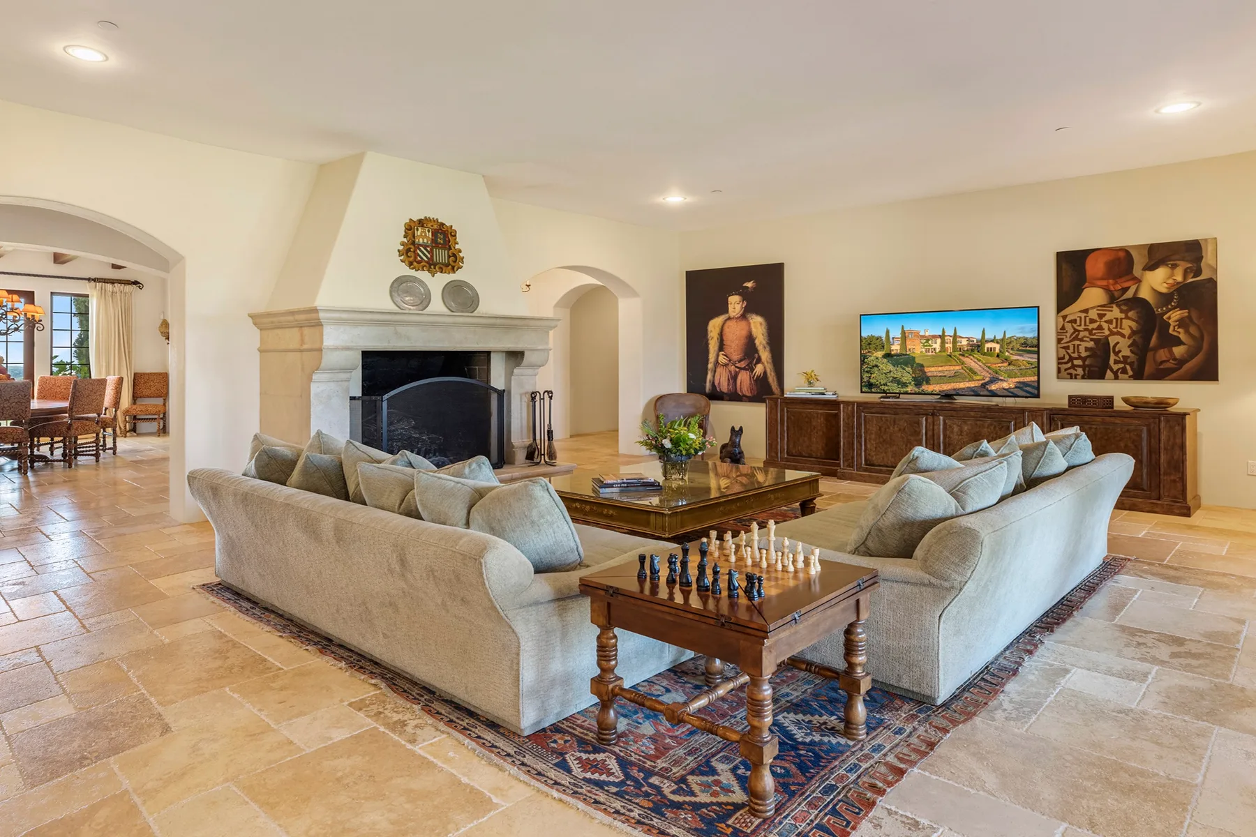 A living room with seating arranged around a coffee table and fireplace.