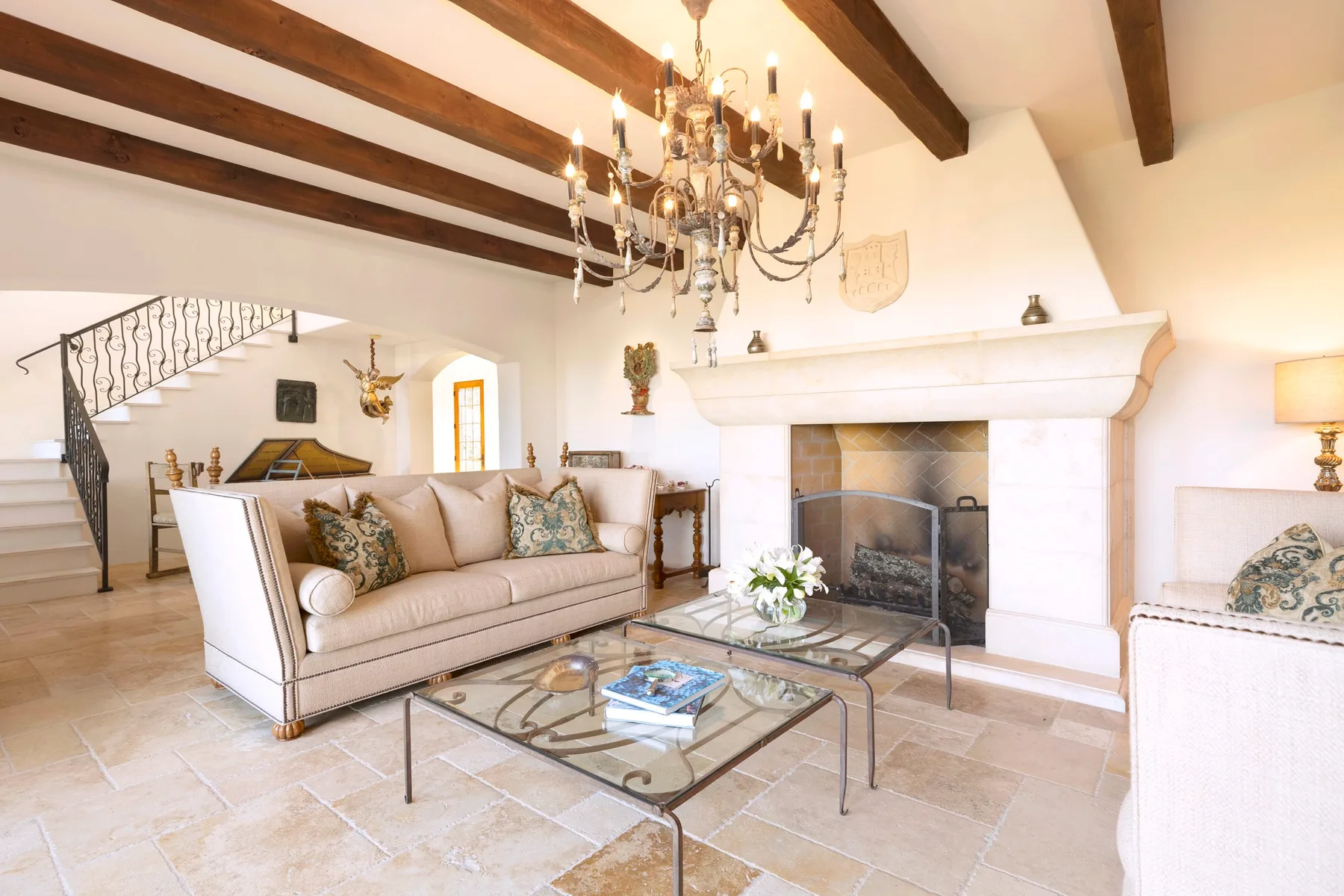 A living room with a fireplace, seating, and a glass coffee table.