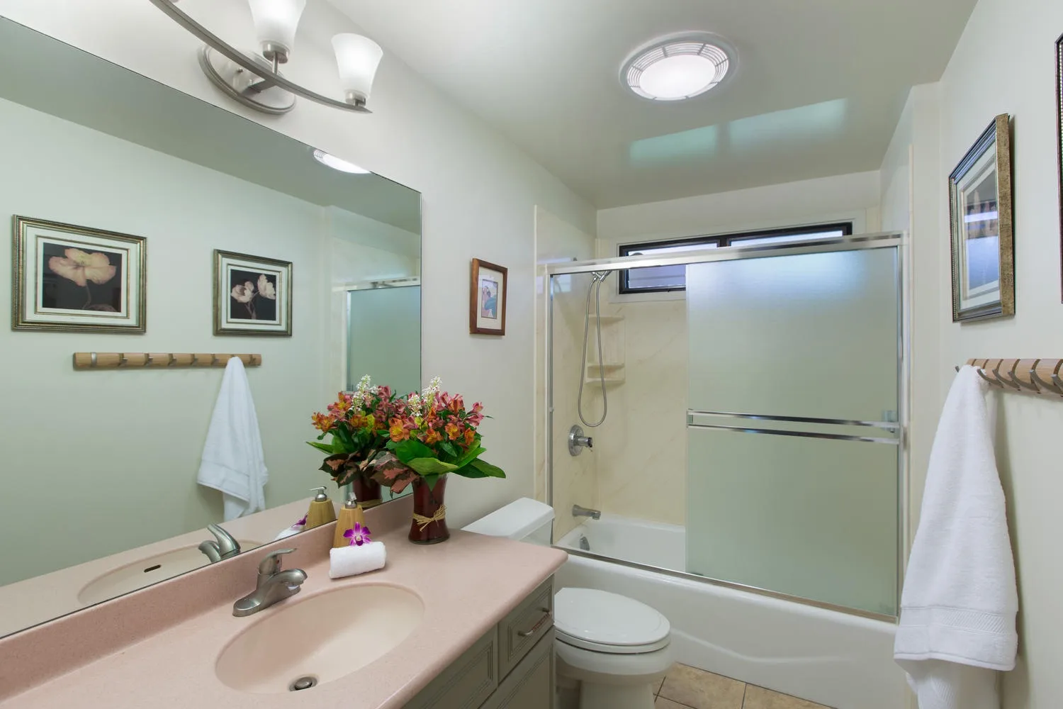 Un baño con lavabo, inodoro y ducha de vidrio.
