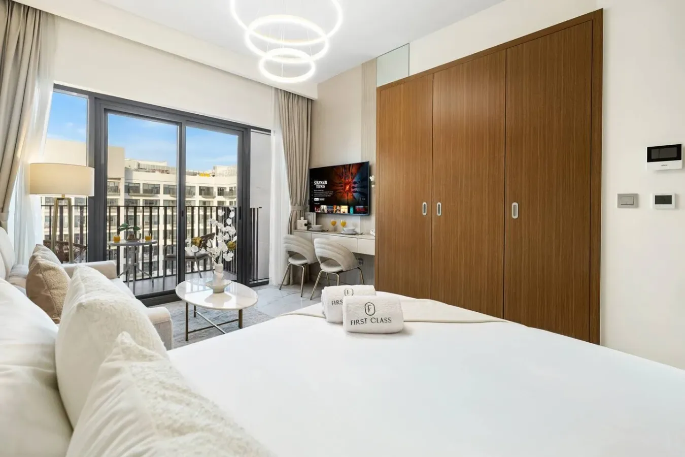 Un dormitorio con una cama grande, armarios de madera y una ventana con balcón.